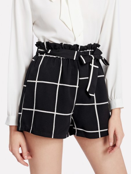 White button down blouse and black plaid shorts with tie