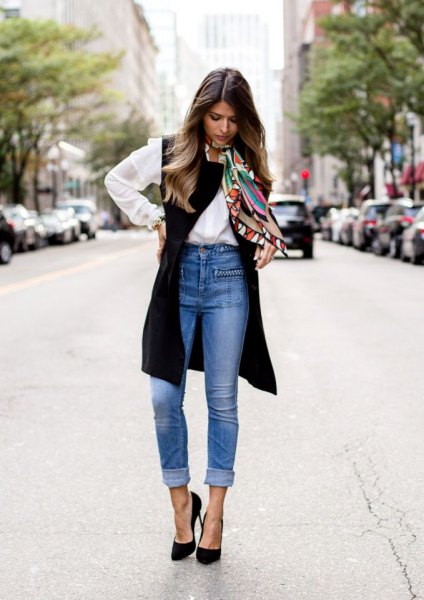 White button down shirt, black long vest and blue high waisted cuffed jeans