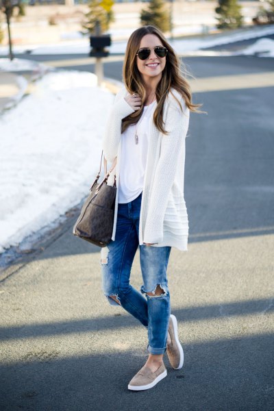White cardigan with blue ripped cuffed jeans and gray loafers
