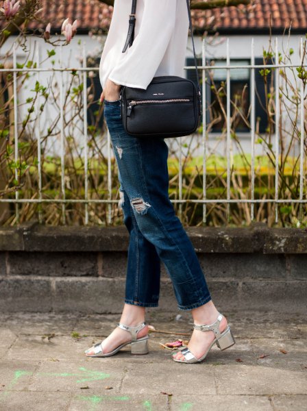 White chiffon blouse with blue ripped slim fit jeans and heeled sandals