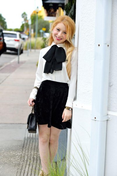 White chiffon blouse with bow tie and black mini skater skirt