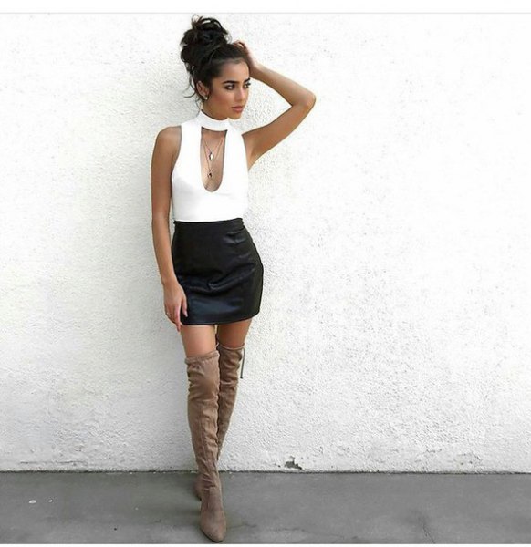 White low-cut sleeveless top with choker and black high-rise mini skirt