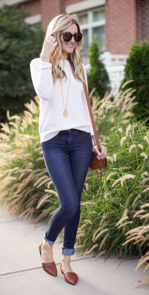 White crew-neck sweater and dark blue skinny jeans with cuffs