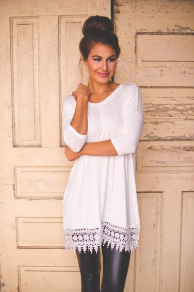 White long tunic top with crochet lace hem and black leather leggings
