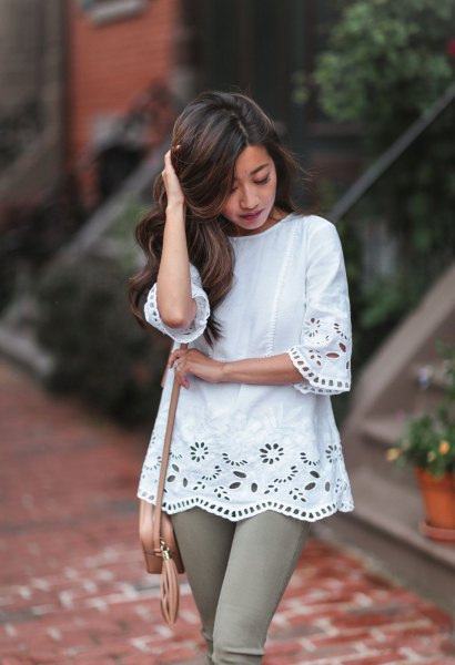 White crocheted lace tunic blouse and gray skinny jeans