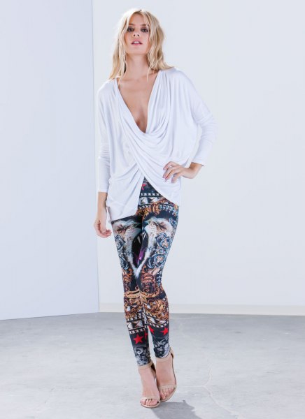 White twist front long sleeve plunging V-neck top paired with tribal print leggings