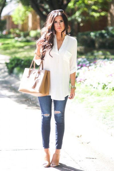 White elegant tunic top with buttons and blue ripped skinny jeans