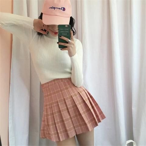 White fitted sweater with pink plaid skirt and white baseball cap