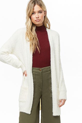 White fluffy longline cardigan with green ribbed high neck sweater
and wide leg trousers