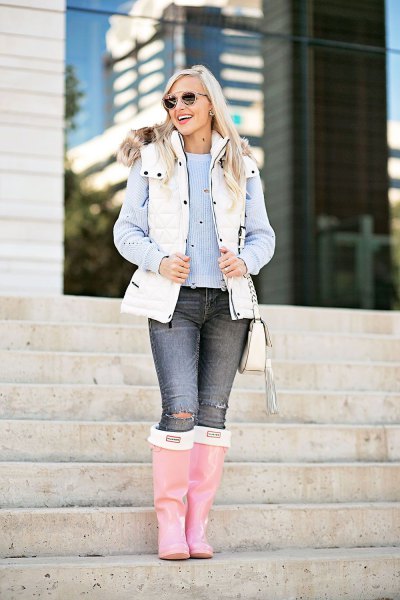 White puffer vest with faux fur collar and hood worn over a blue striped blouse