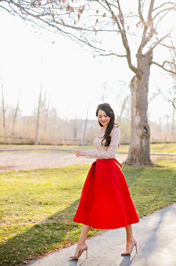 White lace blouse with red flared midi taffeta skirt