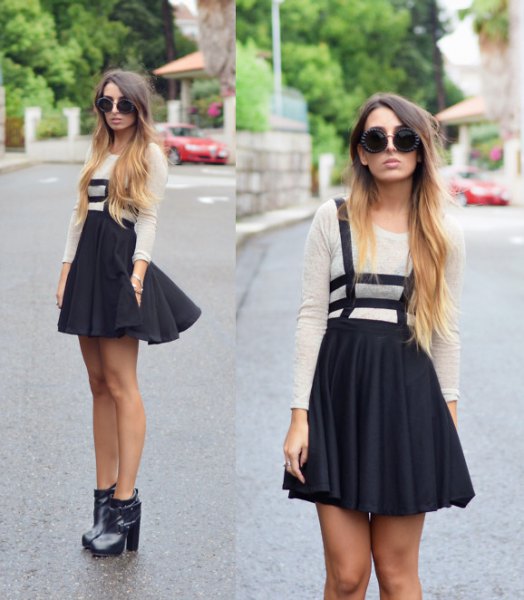 White long sleeve t-shirt with black mini pleated skirt and ankle boots