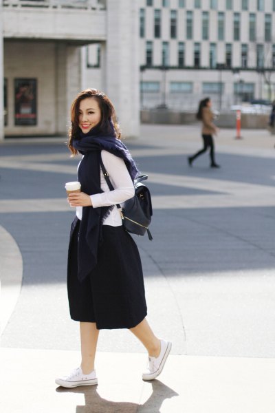 white long sleeve top with black flared midi skirt and backpack handbag