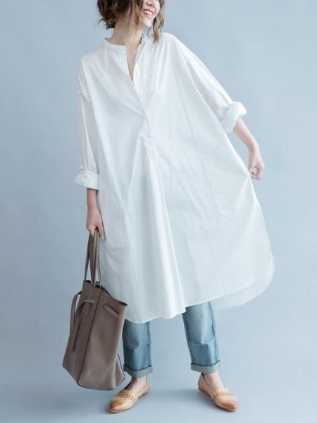 White long-sleeved tunic shirt with blue cuffed jeans and loafers