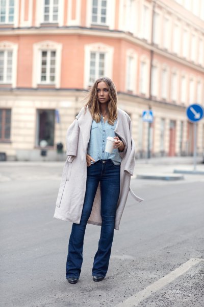 white long wool coat with light blue chambray shirt and dark blue flared jeans