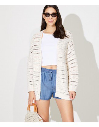 White oversized crochet cardigan with cropped t-shirt and blue
shorts with elastic waistband