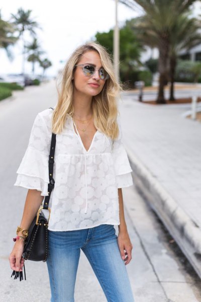 White oversized blouse with ruffle sleeves and light blue skinny jeans