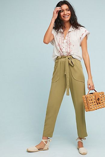 White sleeveless blouse with green short chinos