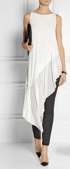 White, sleeveless, high-necked tunic blouse with black skinny jeans