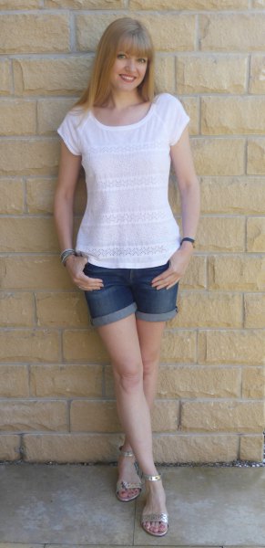 White t-shirt with blue cuffed denim shorts and silver sandals