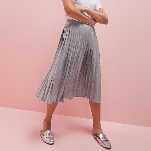 White t-shirt with light gray pleated midi skirt and silver dress shoes