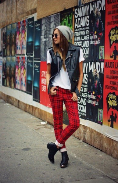White t-shirt with black leather vest and red checked pants