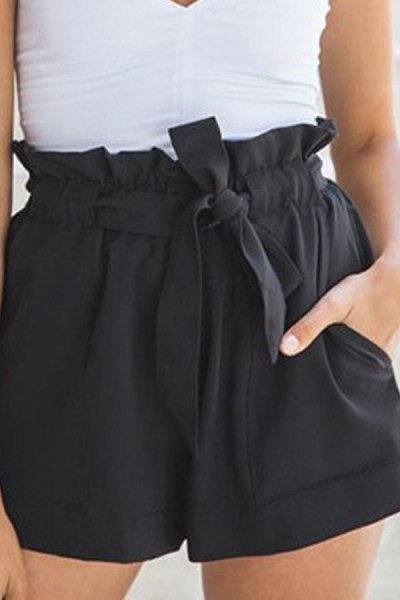 White fitted V-neck sleeveless blouse paired with black mini shorts