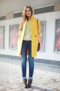 yellow long wool coat with white sweater and jeans with cuffs