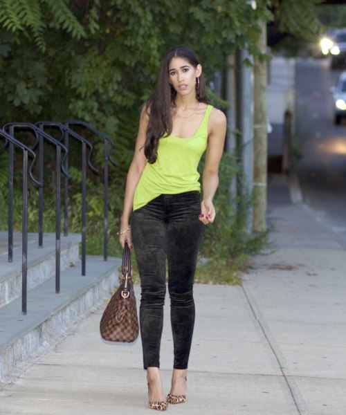 Yellow tank top with a plunging scoop neckline and black velvet ankle length skinny pants