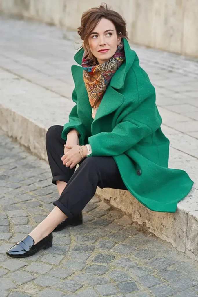 Emerald green coat with embroidered scarf and crumpled jeans